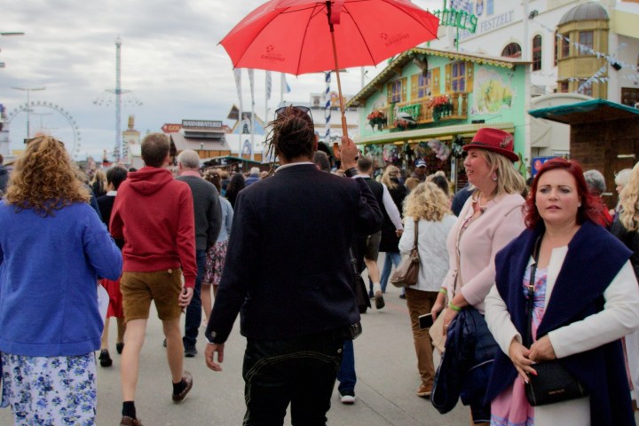 a group of people walking down a street holding an umbrella