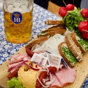 a cup of coffee on a wooden table topped with plates of food