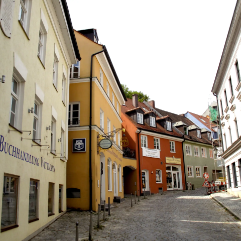 A cobblestone street lined with colorful buildings in the Dachau old town