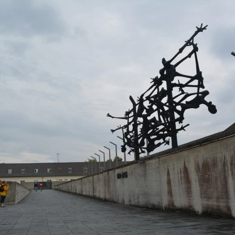 Sculpture resembling twisted figures on a wall at the dachau memorial site