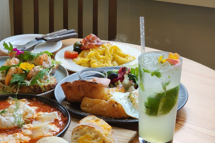 Table setting with a variety of brunch dishes and a green drink.