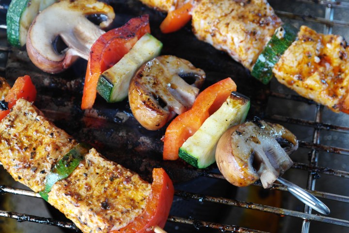 Grilled vegetable and chicken skewers on a barbecue.