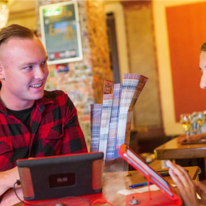 Two people smiling and talking at a table with game cards in a cozy room.