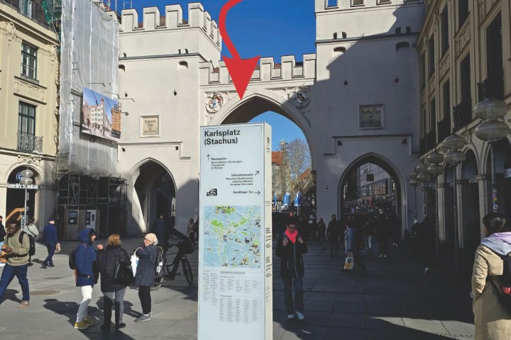 A city gate with people walking, labeled 'Walking Tour Meeting Point,' time '10:15 AM.'