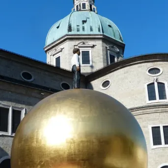Sphaera sculpture in Kapitelplatz with Salzburg Cathedral behind it