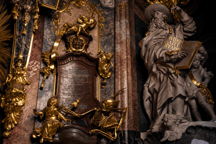 Baroque church interior with gold decorations and sculptures.