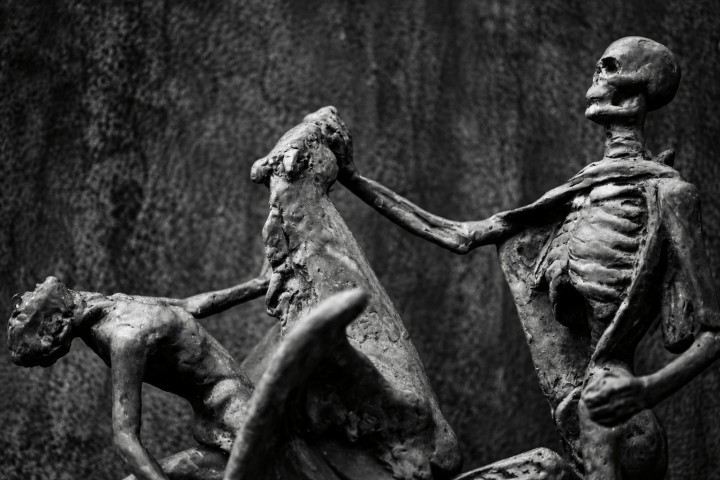 Two skeleton sculptures engaged in a dramatic pose.